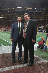 Herb Vincent with CoSIDA Executive Board member Kevin Trainor of Arkansas at the College Football Playoff in 2018.
